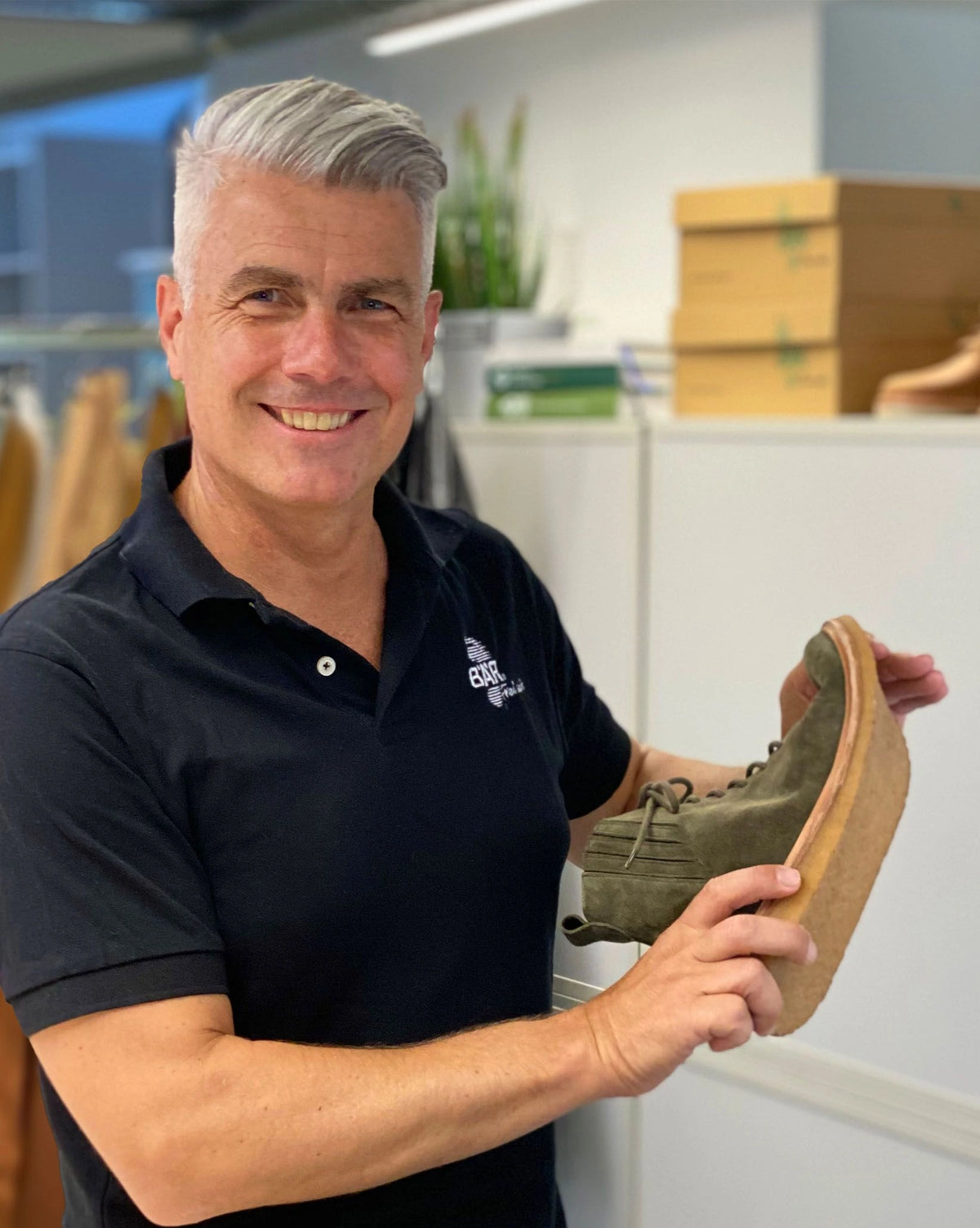 Mann präsentiert einen flexiblen Schuh für breite Füße und zeigt dabei die spezielle Sohle eines BÄR Damenschuhs.