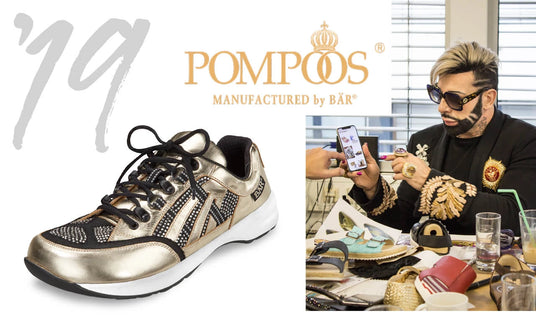 Golden sneaker by Pompoos by Bär, next to a person with a smartphone and a luxurious outfit