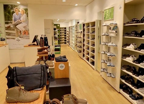 Innenansicht eines modernen Schuhgeschäfts mit Regalen voller Schuhe und einer gemütlichen Atmosphäre