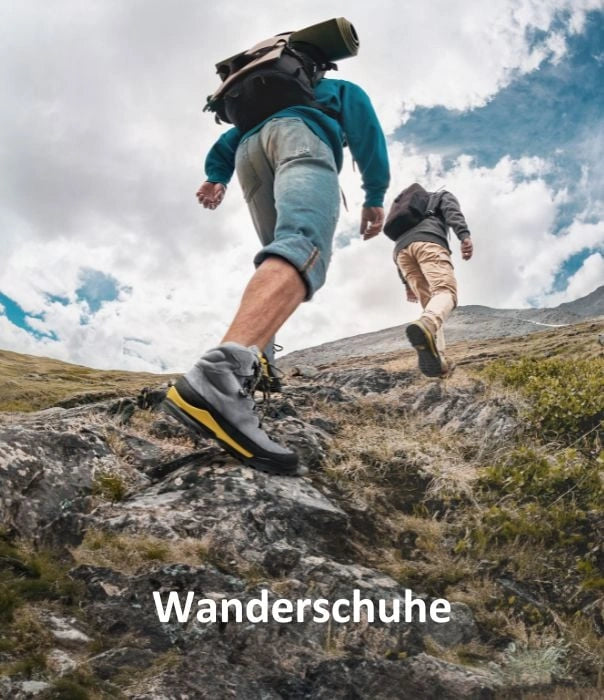 Two hikers ascend a rocky mountain trail, carrying backpacks and sturdy hiking boots.